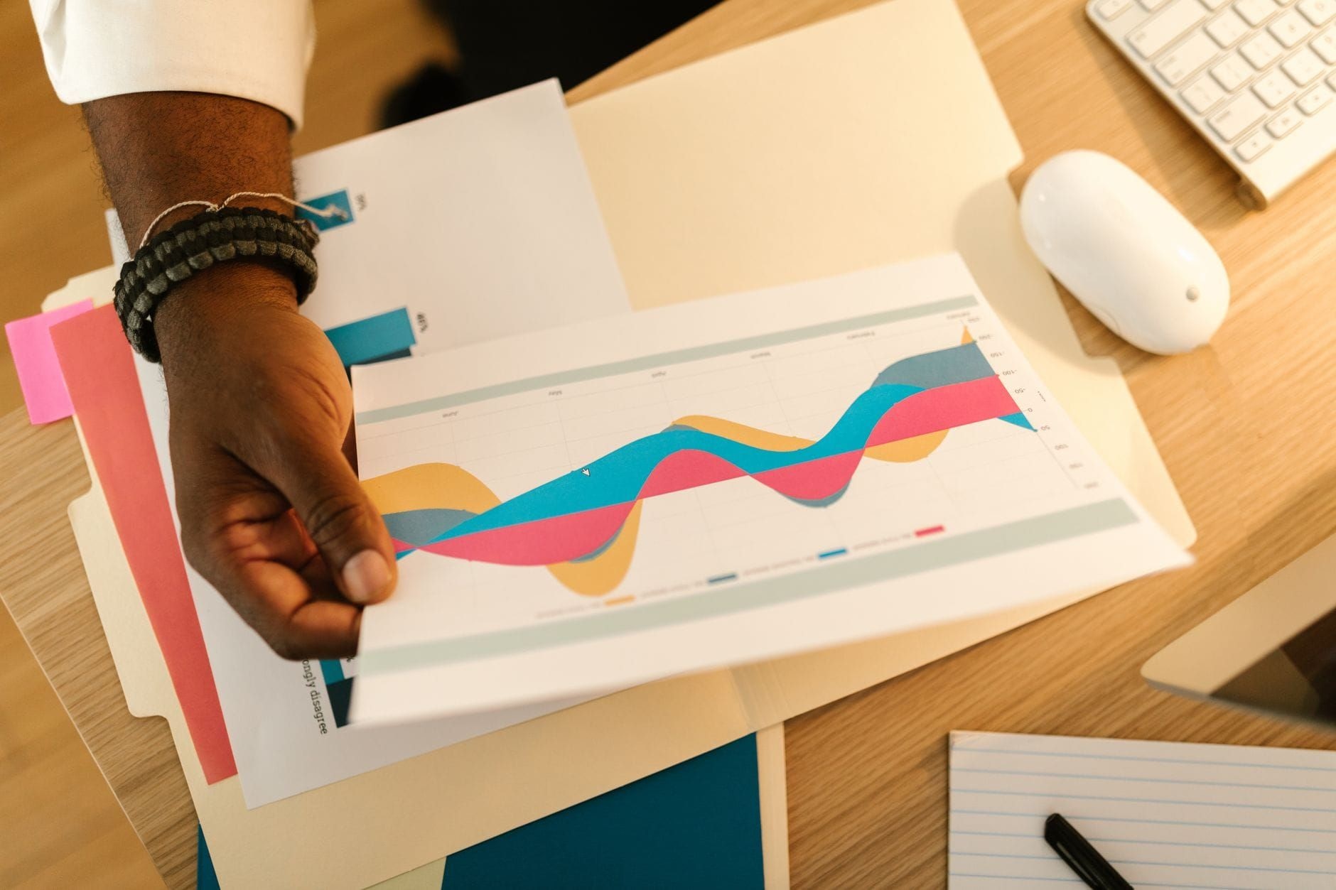 Hand holding a printed performance chart on a desk