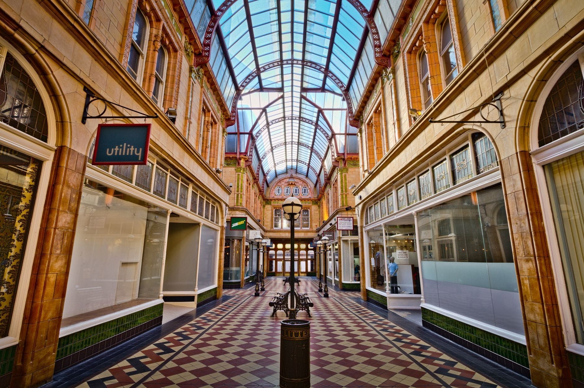 Sunlit vaulted shopping arcade with patterned tile floor